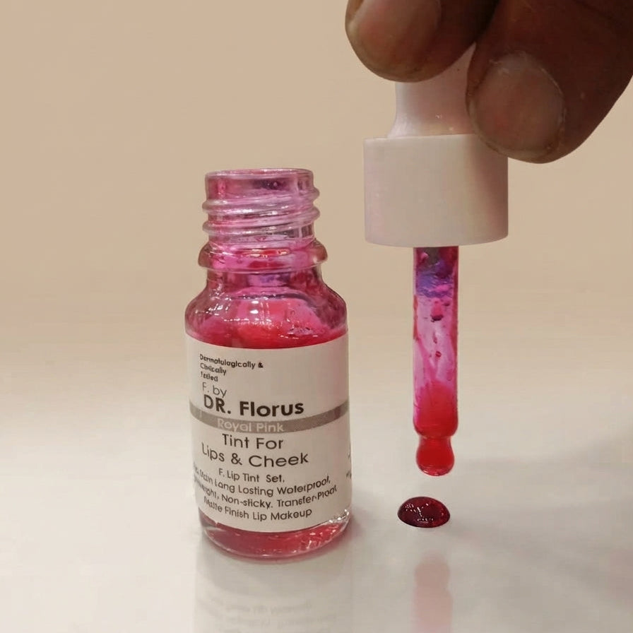 Amber glass bottle of DR. Florus tint in Hot Pink with dropper applicator and a drop on a surface