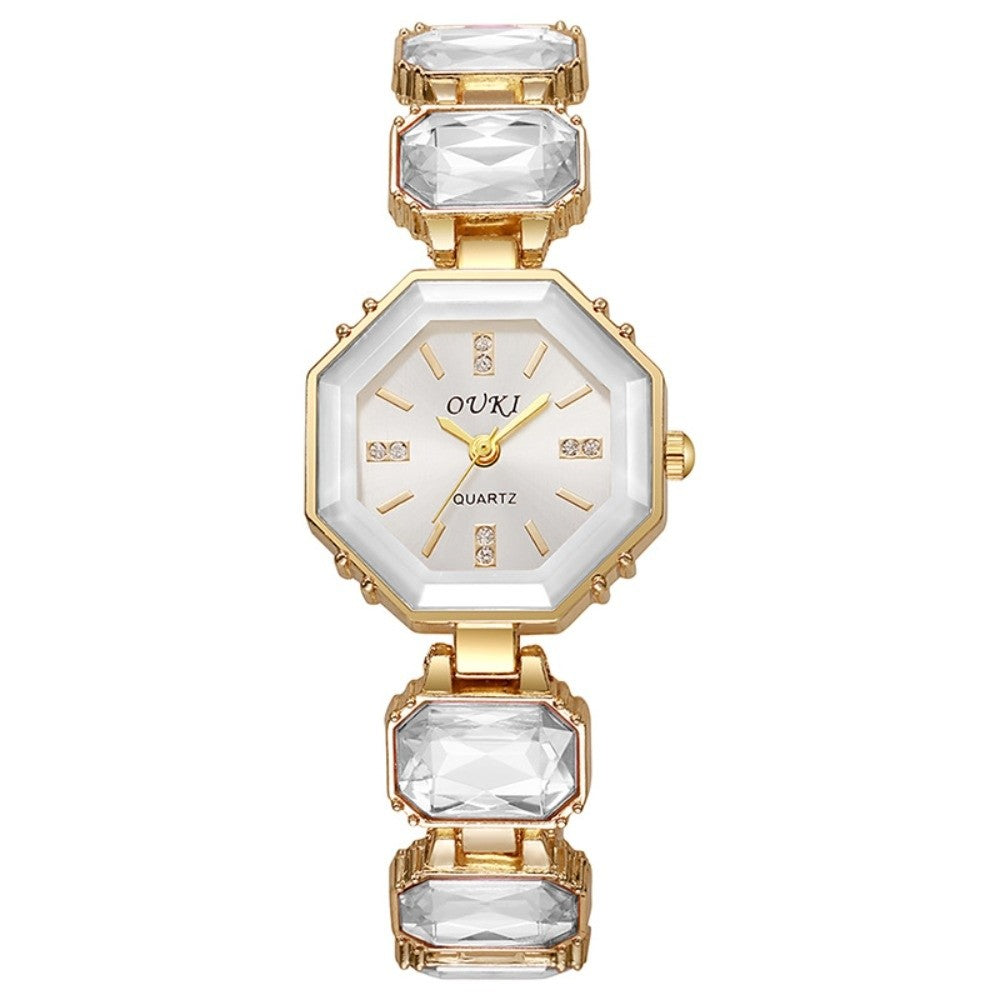 A women's octagonal quartz watch by OUKI, featuring a gold-tone case and bracelet with clear rectangular crystals and a white dial.