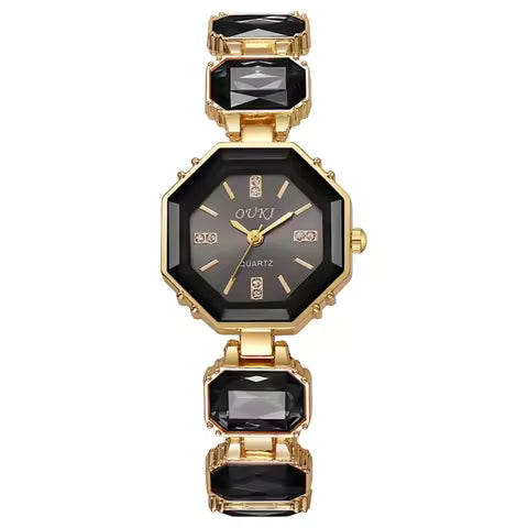 A women's gold-tone octagonal watch with a black dial and black rectangular crystal links on a white background.