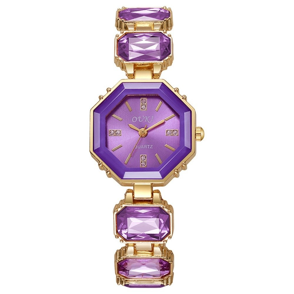 A women's gold-tone octagonal watch with a purple dial and purple rectangular gemstone links on a white background.