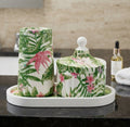 A Zeeno Place tropical botanical bathroom accessory set featuring a green palm leaf pattern, lidded container, and white display tray.
