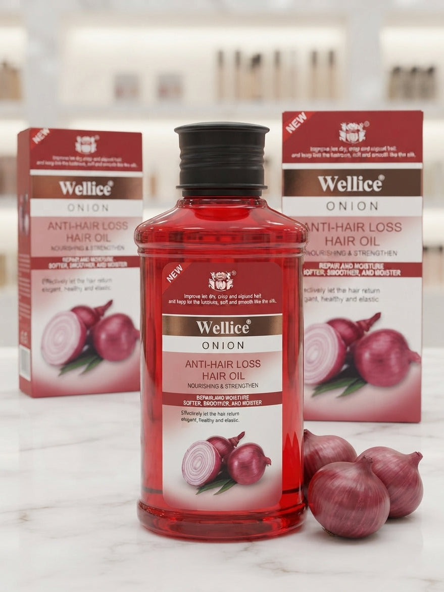 Wellice Onion Anti-Hair Loss Hair Oil red bottle with a black cap, flanked by its red and white packaging boxes and whole onions on a white marble surface.