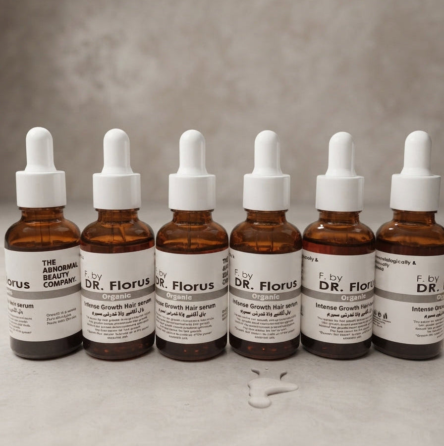 Dr. Florus amber glass bottle of intense growth hair serum with dropper and liquid drops on white surface