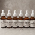 Dr. Florus amber glass bottle of intense growth hair serum with dropper and liquid drops on white surface