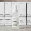 The Ordinary Niacinamide 10% + Zinc 1% face serum bottle with white dropper on a stone surface