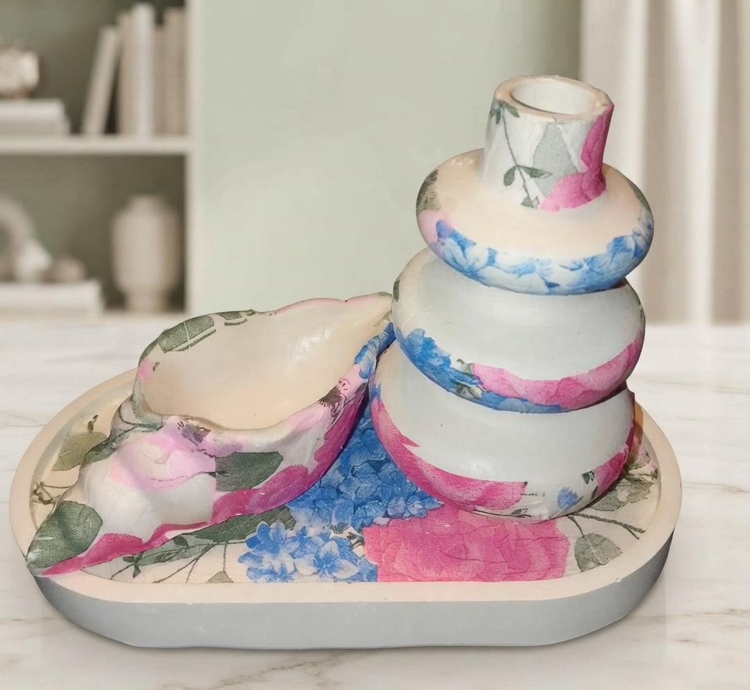 Close up of artistic stacked ceramic vase with pink and blue floral decoupage design