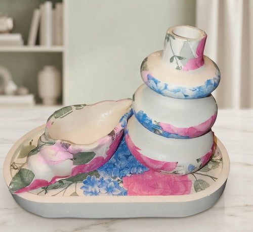 Close up of artistic stacked ceramic vase with pink and blue floral decoupage design
