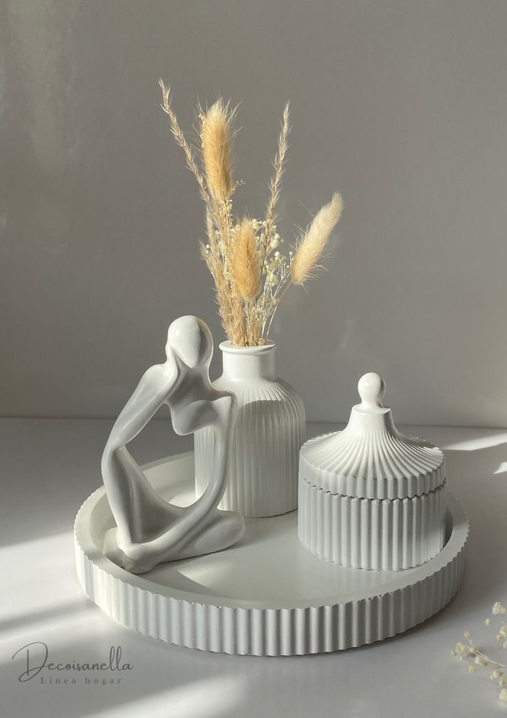 Minimalist matte white ceramic home decor set featuring a thinker statue, ribbed vase with dried pampas grass, lidded jar, and round tray by Zeeno Place